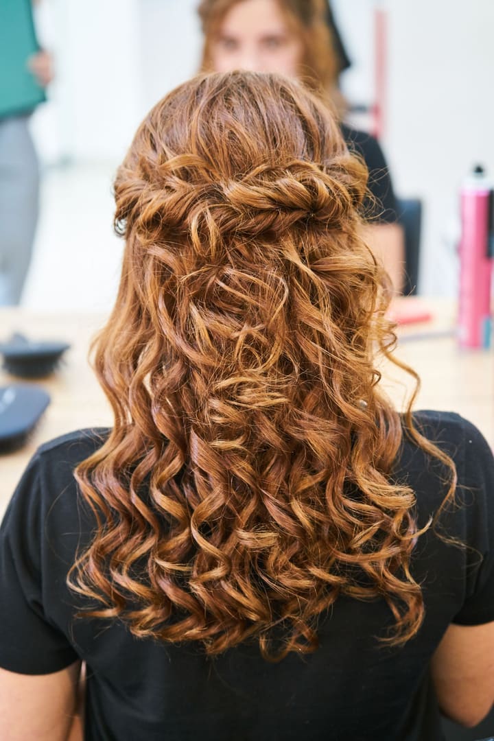 Long copper curls gathered into a half-up twist, seen from behind