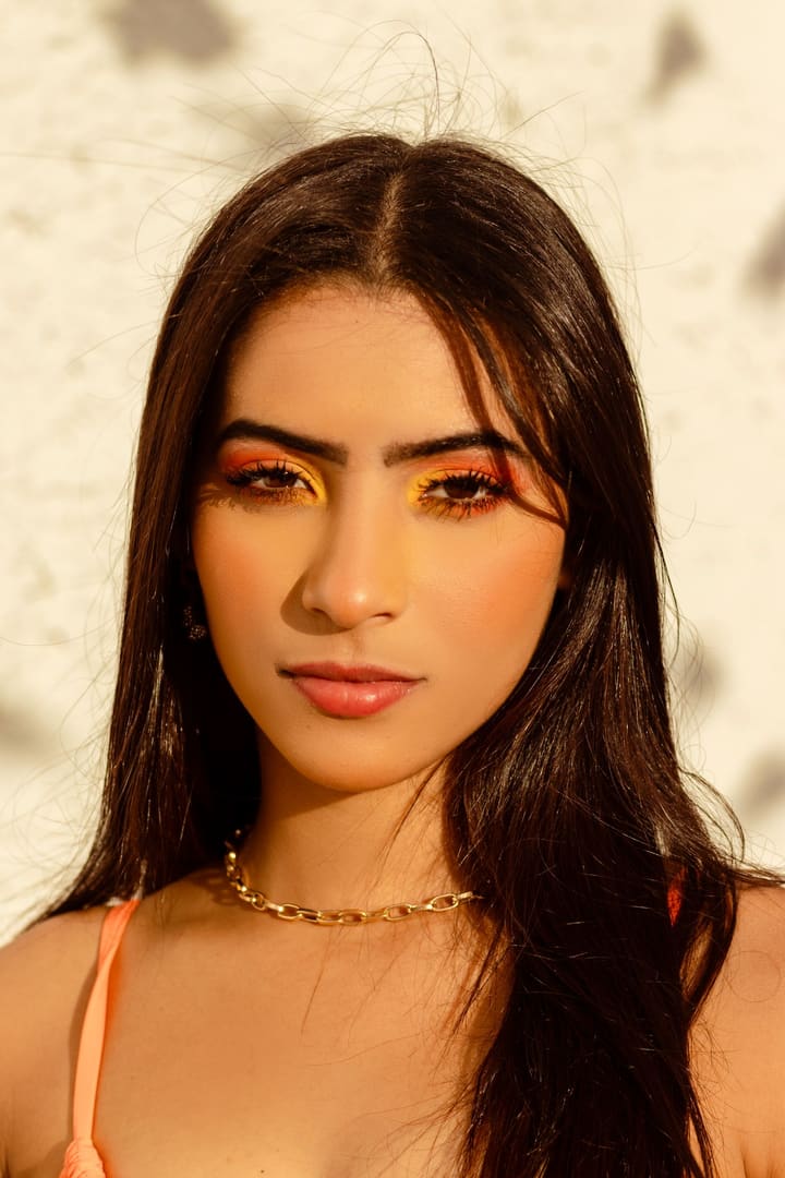 Warm copper eyeshadow and softly defined brows in golden light