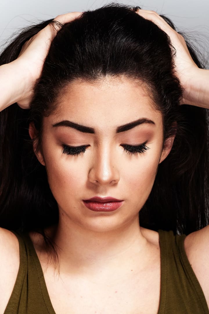 Soft matte makeup with long lashes and a berry lip, eyes lowered