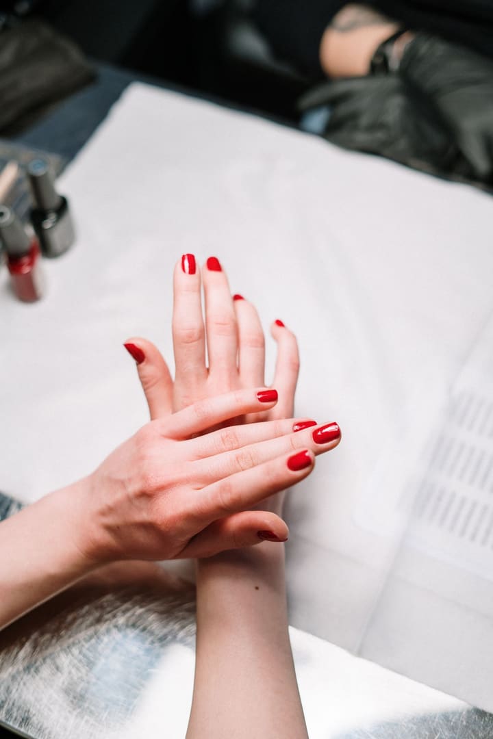 Glossy red nails during a hand massage