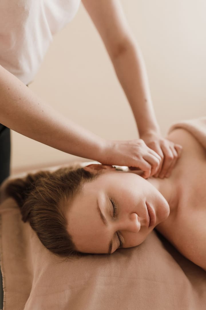 Therapist kneading a guest's shoulders during a massage