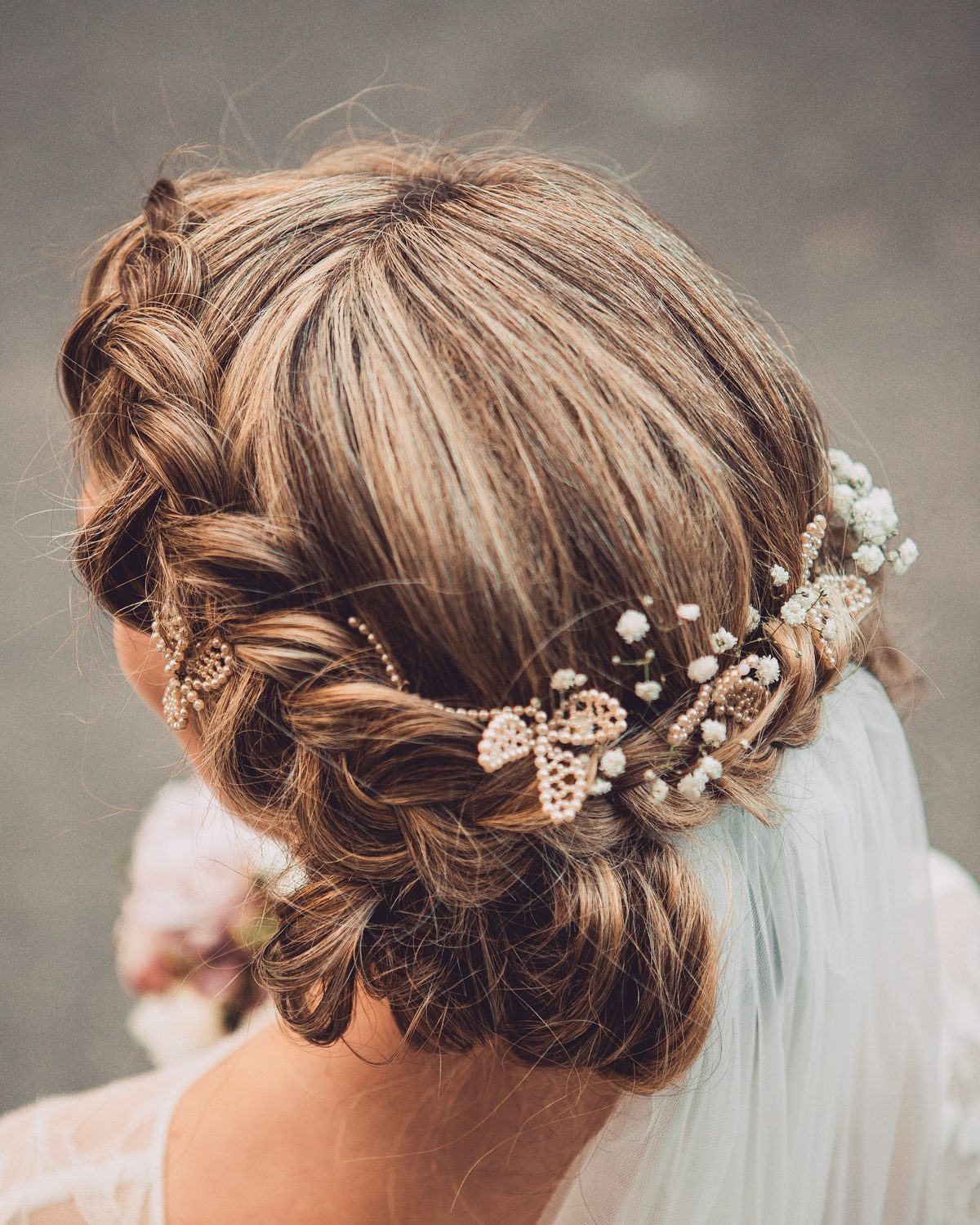 Bridal braided updo finished with a pearl and leaf hair comb and veil